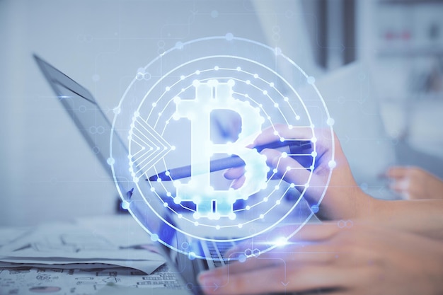 Doble exposición de manos de mujer escribiendo en computadora y holograma de tema de mercado criptográfico dibujando el concepto Blockchain