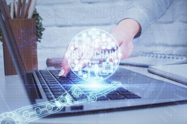 Doble exposición de manos de mujer escribiendo en computadora y holograma de tema de mercado criptográfico dibujando el concepto Blockchain