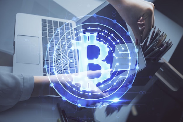 Doble exposición de manos de mujer escribiendo en computadora y holograma de tema de mercado criptográfico dibujando el concepto Blockchain