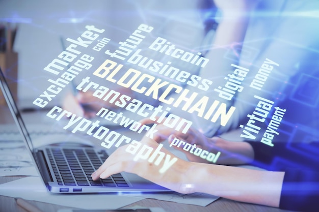 Doble exposición de manos de mujer escribiendo en computadora y holograma de tema de mercado criptográfico dibujando el concepto Blockchain