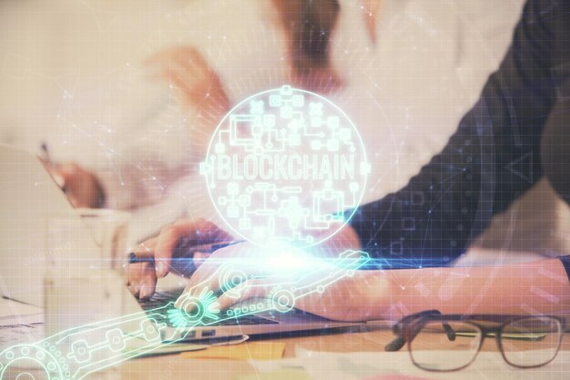 Doble exposición de manos de mujer escribiendo en computadora y holograma de tema de mercado criptográfico dibujando el concepto Blockchain