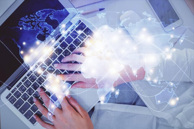 Doble exposición de manos de mujer trabajando en computadora y holograma de tema financiero dibujo concepto de negocio de vista superior