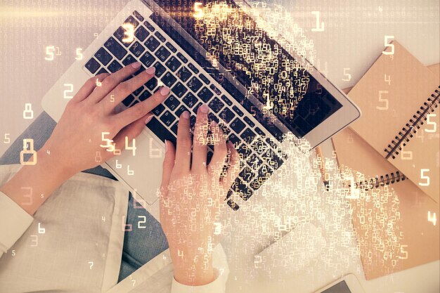 Doble exposición de manos de mujer trabajando en computadora y holograma de tema tecnológico dibujando el concepto de tecnología Top View