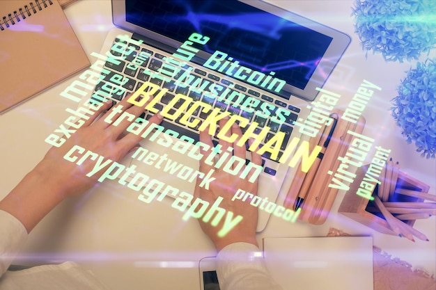 Doble exposición de manos de mujeres trabajando en computadora y dibujo holográfico de tema blockchain Top View concepto de criptomoneda bitcoin