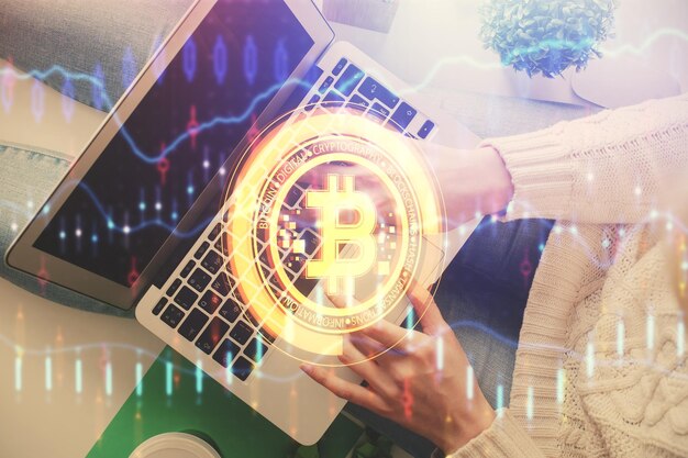 Doble exposición de manos de mujeres trabajando en computadora y dibujo holográfico de tema blockchain Top View concepto de criptomoneda bitcoin