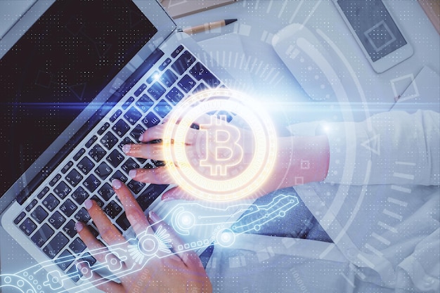 Doble exposición de manos de mujeres trabajando en computadora y dibujo holográfico de tema blockchain Top View concepto de criptomoneda bitcoin