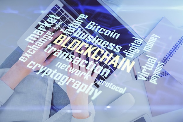Doble exposición de manos de mujeres trabajando en computadora y dibujo holográfico de tema blockchain Top View concepto de criptomoneda bitcoin