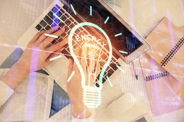 Doble exposición de manos de mujeres trabajando en computadora y dibujo de hologramas de bombillas Top View Idea concept