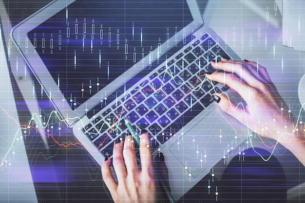 Doble exposición de manos de mujeres trabajando en computadora y dibujo de hologramas de gráficos de divisas Vista superior Concepto de análisis financiero