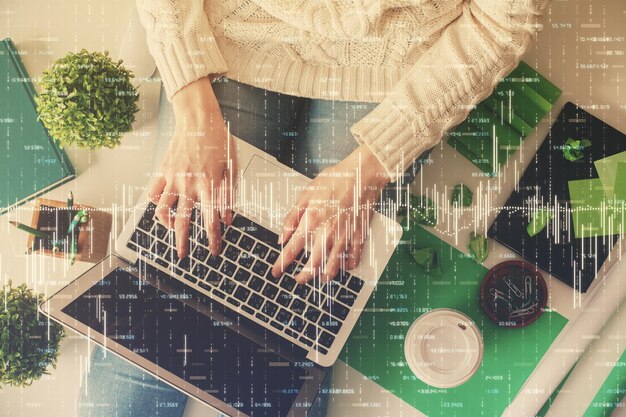 Doble exposición de manos de mujeres trabajando en computadora y dibujo de hologramas de gráficos de divisas Vista superior Concepto de análisis financiero