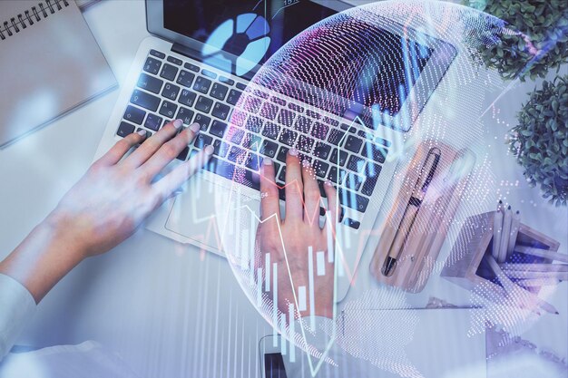 Doble exposición de manos de mujeres trabajando en computadora y dibujo de hologramas de gráficos de divisas Vista superior Concepto de análisis financiero