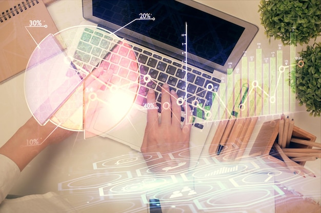 Doble exposición de manos de mujeres trabajando en computadora y dibujo de hologramas de gráficos de divisas Vista superior Concepto de análisis financiero