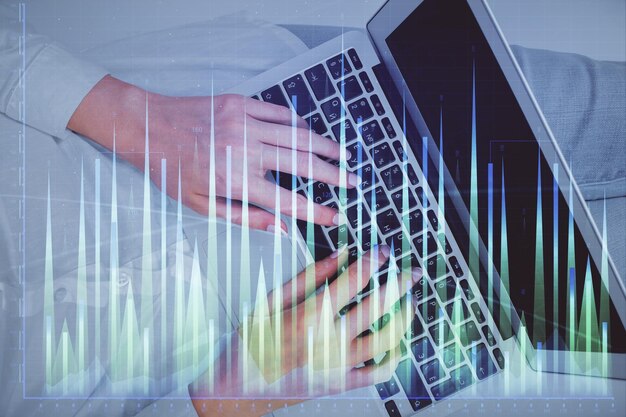 Doble exposición de manos de mujeres trabajando en computadora y dibujo de hologramas de gráficos de divisas Vista superior Concepto de análisis financiero