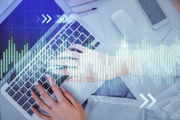 Doble exposición de manos de mujeres trabajando en computadora y dibujo de hologramas de gráficos de divisas Vista superior Concepto de análisis financiero