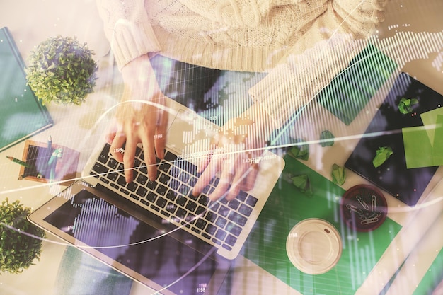 Doble exposición de manos de mujeres trabajando en computadora y dibujo de hologramas de gráficos de divisas Vista superior Concepto de análisis financiero