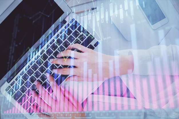 Foto doble exposición de manos de mujeres trabajando en computadora y gráfico de divisas dibujo holográfico top view concepto de análisis financiero