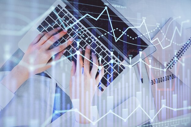 Doble exposición de manos de mujeres trabajando en computadora y gráfico de divisas dibujo holográfico Top View Concepto de análisis financiero