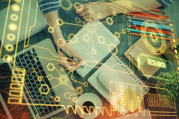 Doble exposición de las manos tomando notas con iconos de codificación digital Concepto de aprendizaje por computadora