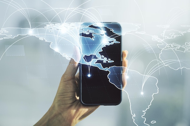 Doble exposición del mapa del mundo digital abstracto con conexiones y mano con teléfono celular en el concepto de big data y blockchain de fondo