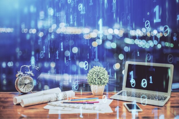 Doble exposición de la mesa con la computadora en el fondo y el concepto de tecnología de datos del holograma del tema de los datos