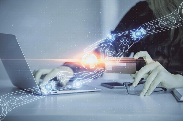 Doble exposición de una mujer que compra en línea con una tarjeta de crédito y un holograma de tema de datos que dibuja el concepto de comercio electrónico