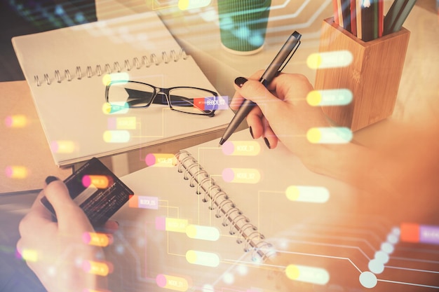 Doble exposición de una mujer que compra en línea con una tarjeta de crédito y un holograma de tema de datos que dibuja el concepto de comercio electrónico
