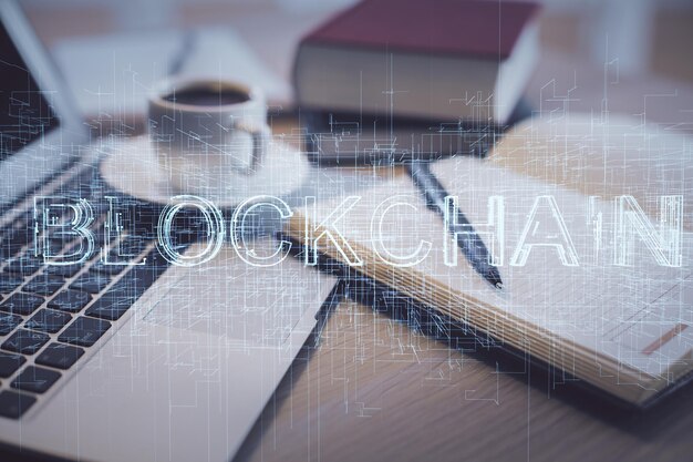 Doble exposición de la tecnología de criptografía dibujo y escritorio con café y artículos en el fondo de la mesa Concepto de blockchain