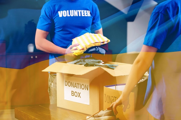 Doble exposición de voluntarios empacando cajas de donación y bandera ucraniana Ayuda durante la guerra