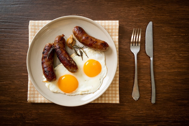 Doble huevo frito casero con salchicha de cerdo frita - para el desayuno