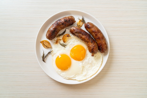 doble huevo frito casero con salchicha de cerdo frita - para el desayuno