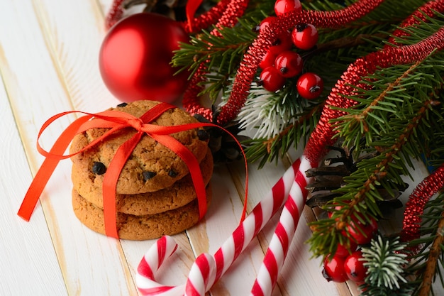 Doce arranjo de bastões de doces listrados e pilha de deliciosos biscoitos embrulhados com fita vermelha.