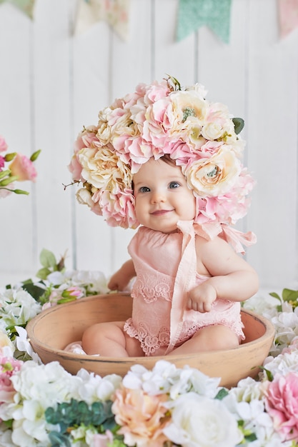 Doce bebê engraçado no chapéu com flores. páscoa. menina bonito 6 meses usando chapéu de flor.