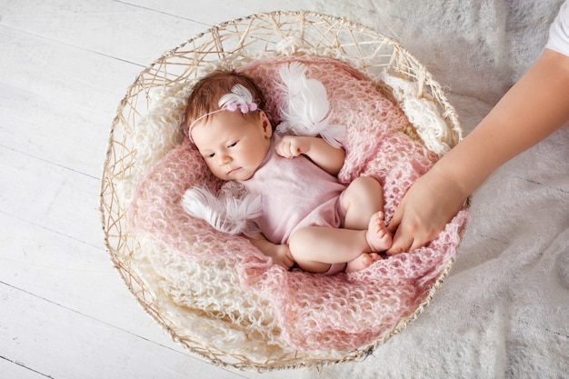 Doce bebê recém-nascido dorme com um brinquedo na cesta.