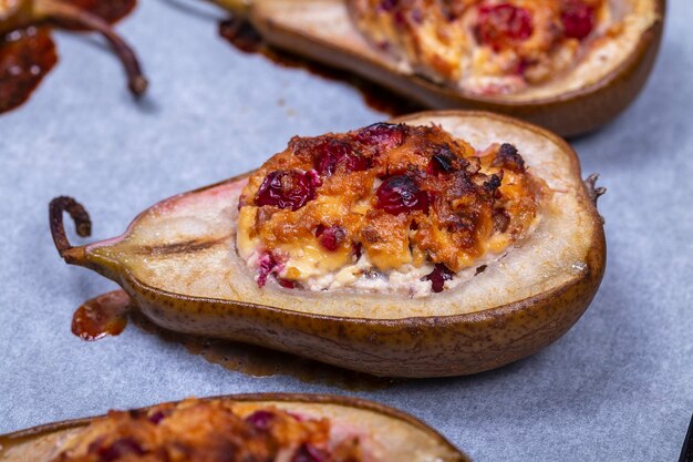 Doce caseiro cozido peras com mel, nozes, cranberries e canela, close-up. Sobremesa de peras doces duquesa assadas em caramelo e geléia