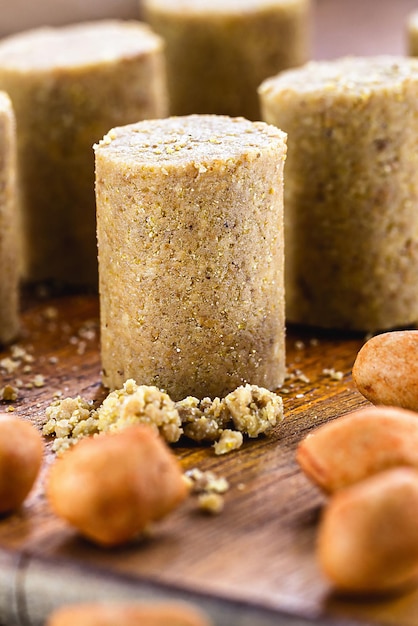 Doce de amendoim na mesa rústica com pedaços de amendoim ao redor da pacoca brasileira macrofotografia comida típica das festas juninas