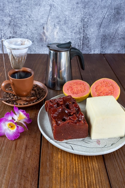 Doce de goiaba e requeijão ao lado de grãos de xícara de flores e filtro de café de pano