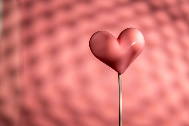 Doce de pirulito em forma de coração rosa dia dos namorados em fundo de papel pastel vazio conceito de amor