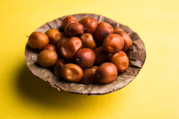 Doce indiano Jujuba ou ber ou baga ou Ziziphus mauritiana, em uma tigela ou sobre fundo branco