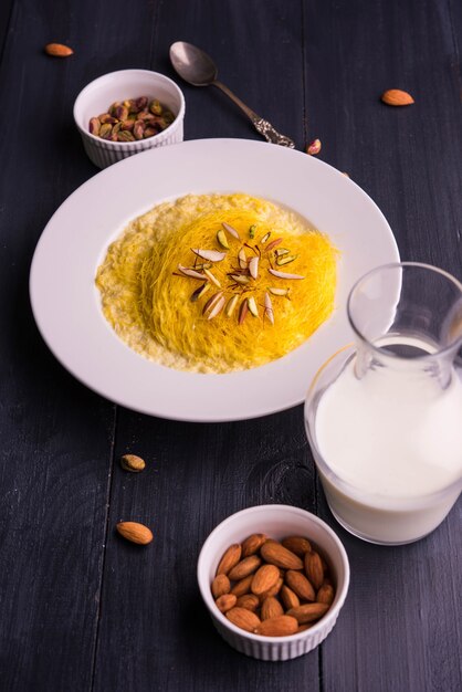 Doce indiano kesar sutarfeni ou sutar feni ou firni ou seviyan ou laccha, farinha de arroz fragmentada torrada em ghee, misturada com açúcar derretido para formar um algodão doce, com pistache e amêndoas