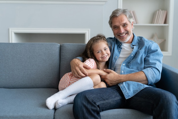 Doce menina feliz abraçando o pai em casa.