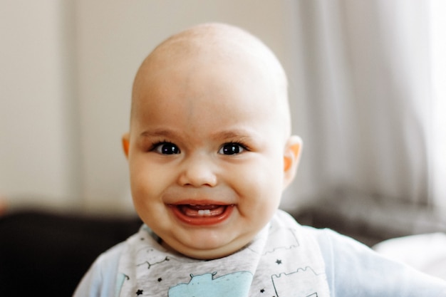 Doce menininho com bochechas rechonchudas e olhos grandes. Retrato de criança feliz e sorridente