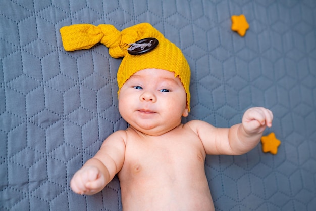 Doce menino sorrindo Bonito menino recém-nascido com chapéu amarelo engraçado