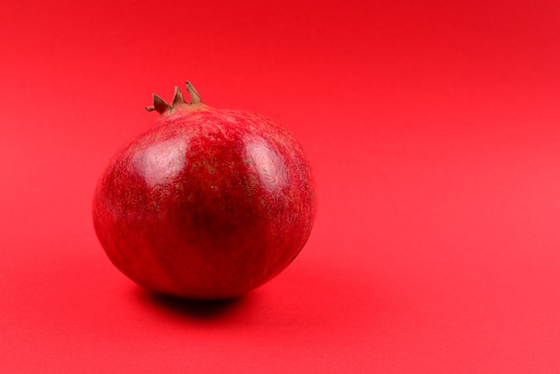 Doce romã em fundo vermelho