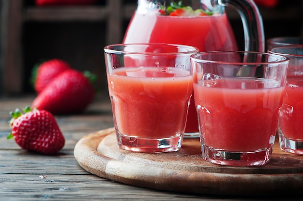 Doce suco de morango fresco na mesa de madeira