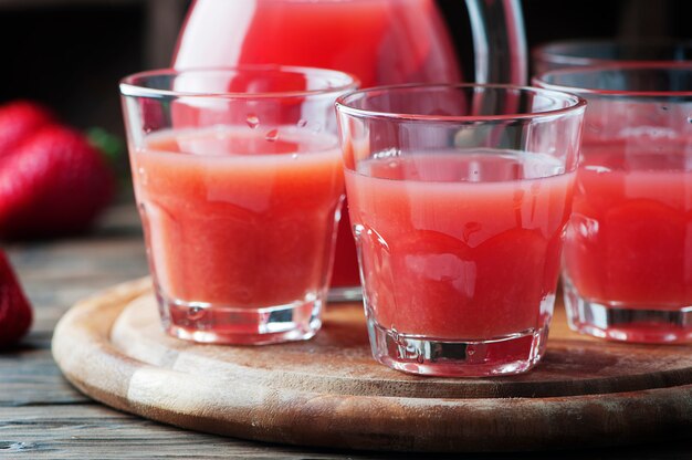 Doce suco de morango fresco na mesa de madeira