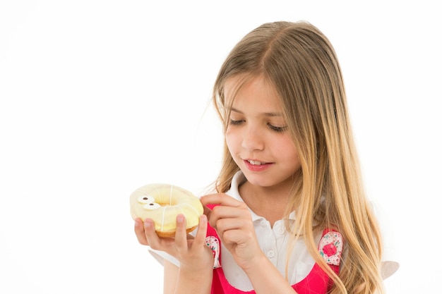 Foto doce tesouro garota calma rosto segura rosquinha doce na mão isolado branco garota de cabelo comprido gosta de rosquinhas conceito de lanche a criança gosta de comer rosquinhas com coberturas coloridas copie o espaço