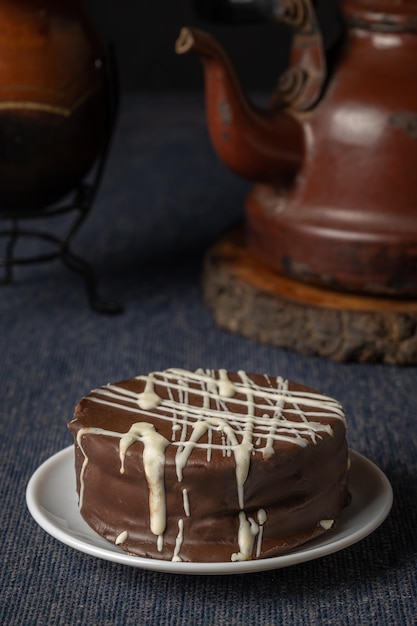 Doce típico alfajor de chocolate marrom na Argentina com erva-mate e uma chaleira