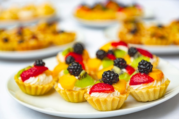 Doces apetitosos em forma de cestos com frutas, bagas e nozes