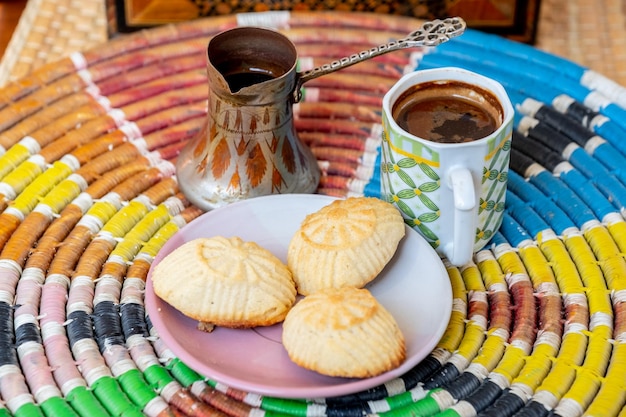 Doces árabes maamoul e café em fundo tradicional