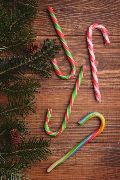 Doces coloridos brilhantes varas contra o pano de fundo da árvore de Natal